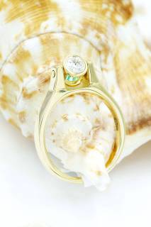Ring with emerald and diamond in an hourglass composition