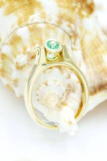 Ring with emerald and diamond in an hourglass composition