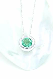Pendant with emrald in a circular composition